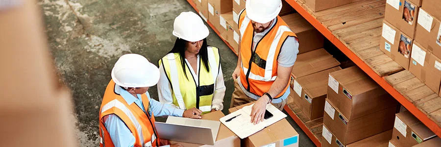 A man and a woman wearing safety helmets and high-visibility vests